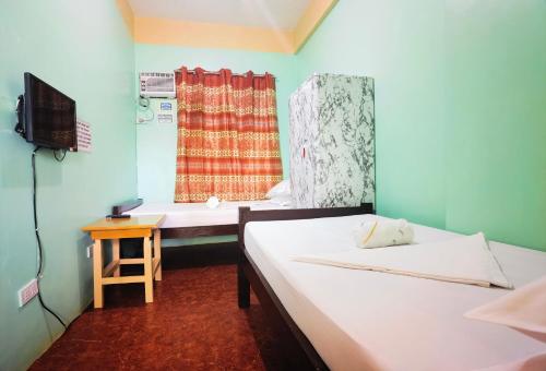 土格加劳RedDoorz D128 Lodge Cagayan Valley的客房设有两张床、一台电视和一扇窗户。