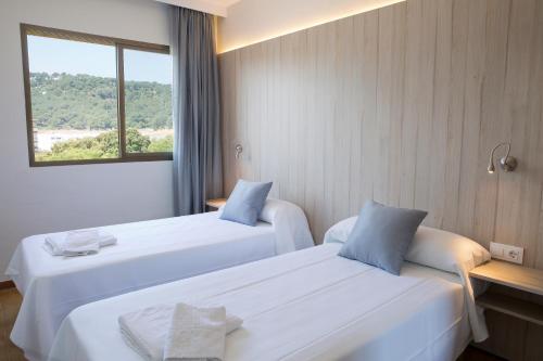 滨海托萨托萨公园GHT公寓式酒店的配有窗户的酒店客房内的两张床