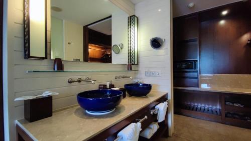 三亚三亚鹿回头度假酒店的浴室设有2个蓝色水槽和镜子
