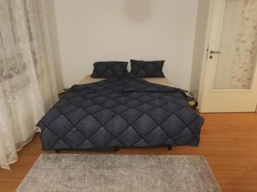 赛斯韦泰Iver apartman的卧室内的一张带黑色棉被的床