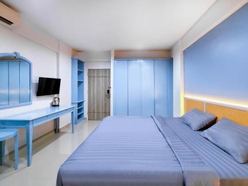 巴吞他尼Chateau Hotel & Apartments的蓝色卧室配有一张床和一张书桌