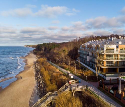 尤斯托尼莫斯基Ustronie Apartments z widokiem na morze 20 m do plaży的海边的一栋建筑