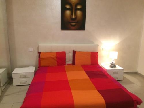 马格拉Mechai Boatto Tumpat的卧室配有色彩缤纷的床,墙上设有一张面孔