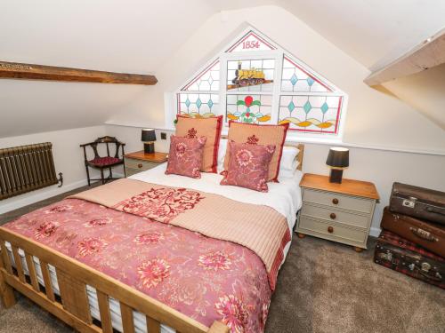 基德明斯特Station Masters Cottage的一间卧室设有一张床和一个彩色玻璃窗