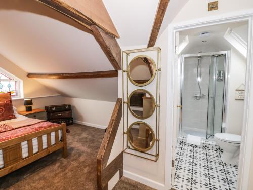 基德明斯特Station Masters Cottage的带淋浴的浴室和客房内的一张床
