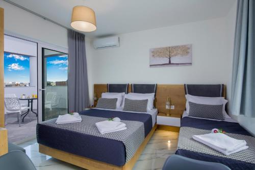 干尼亚Deluxe City Hotel的酒店客房设有两张床和一个阳台。