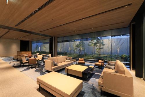 京都Richmond Hotel Premier Kyoto Shijo的大堂配有沙发、桌子和窗户。