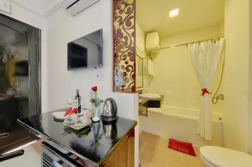 会安海延酒店的浴室配有盥洗盆、卫生间和浴缸。