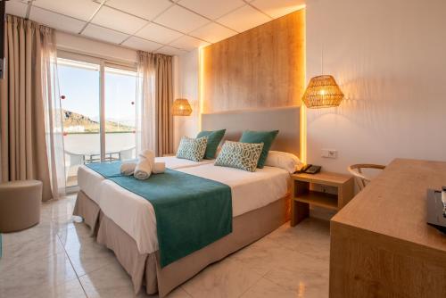 阿尔库迪亚港Bahía de Alcudia Hotel & Spa的一间设有大床和窗户的酒店客房