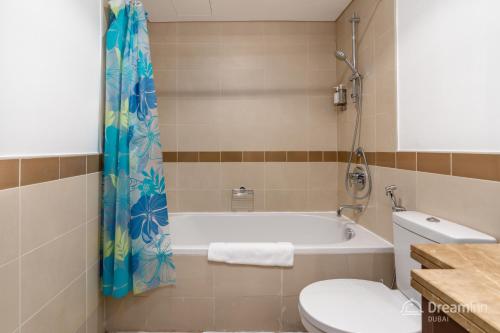 迪拜Dream Inn Apartments - 29 Boulevard Private Terrace的带浴缸和卫生间的浴室。