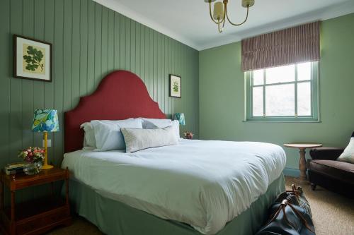 纽伯里The Retreat, Elcot Park的一间卧室配有一张大床和红色床头板