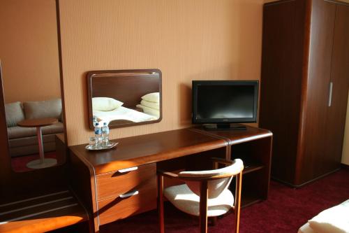 Borek Wielkopolski尹普雷斯汽车旅馆的客房设有一张带电视和镜子的书桌。