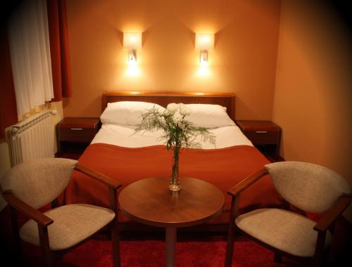 Borek Wielkopolski尹普雷斯汽车旅馆的酒店客房配有一张带桌椅的床。