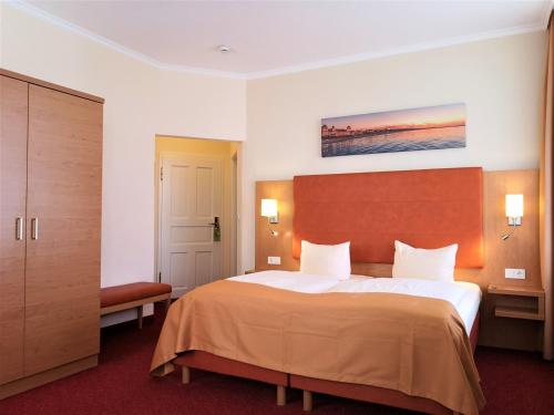 宾茨美瑞格斯酒店的酒店客房带一张大床,带白色床单