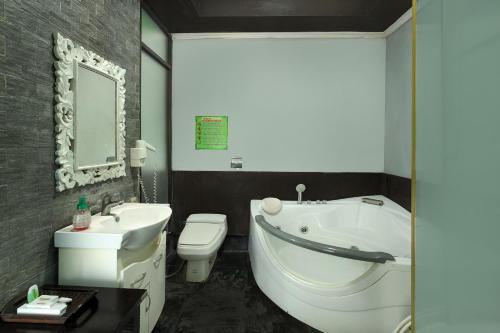 NegaraNegara Hotel - CHSE Certified的浴室配有白色浴缸、卫生间和水槽。