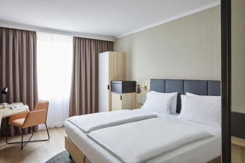汉堡Crowne Plaza Hamburg-City Alster, an IHG Hotel的酒店客房设有一张大床和一张书桌。