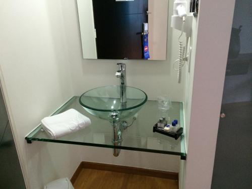 马尼萨莱斯贝尼多姆酒店的一间带玻璃水槽和镜子的浴室
