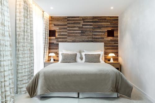 圣特罗佩Villa Cosy, hotel & spa的一间卧室设有一张大床和砖墙