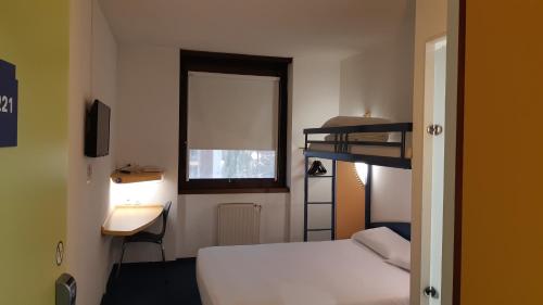蒙托邦Kyriad Direct Montauban Centre的一间卧室配有一张床、一张桌子和一张双层床。