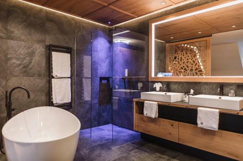 布鲁尼科Majestic Hotel & Spa Resort的一间带两个盥洗盆和大浴缸的浴室