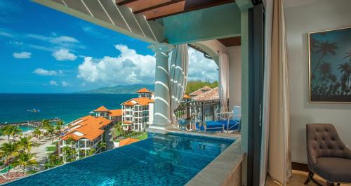 BambooSandals Grenada All Inclusive - Couples Only的设有一个游泳池的度假村阳台,享有风景