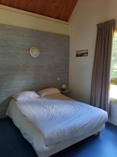 AubazinesHôtel du golf du coiroux的一间卧室设有一张带木墙的大床