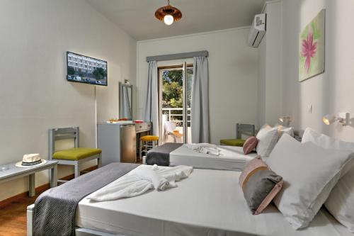 海若克利欧Asterion Hotel的酒店客房设有两张床和电视。