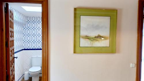 托莱多Ático Las termas的墙上有绘画的浴室和卫生间