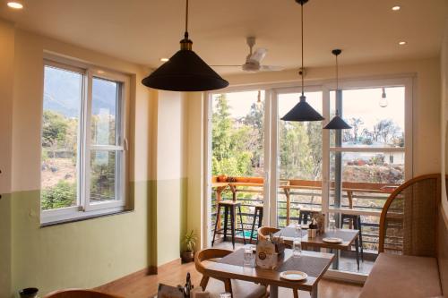 达兰萨拉SERENE SUITES的用餐室设有桌椅和窗户。