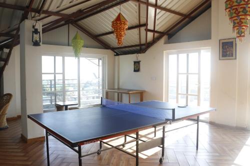 达兰萨拉SERENE SUITES的带窗户的客房内的乒乓球桌