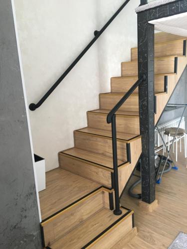 博罗沃耶Современные и уютные аппартаменты的木楼梯和黑色栏杆的楼梯