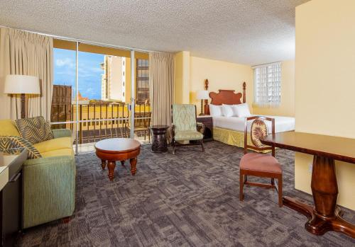 檀香山Ohia Waikiki Studio Suites的酒店客房带一间卧室、一张床和一个阳台