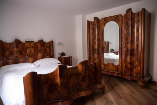 Ono San PietroB&B LE AQUANE的一间卧室配有一张木床和大镜子