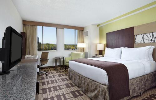 银泉Hotel Silver Spring的一间酒店客房,配有一张大床和一台平面电视