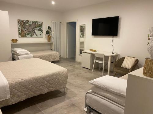 布德里奥A casa di Lella的一间酒店客房,设有两张床、一张桌子和一台电视机