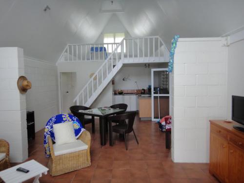 拉罗汤加贝塔拉海滨度假屋 的一间带桌椅和楼梯的客厅