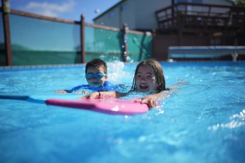 阿卡罗阿阿卡罗阿十大假日公园的男孩和女孩在游泳池游泳