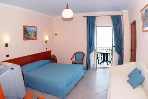 罗迪-加尔加尼科特拉蒙托公寓式酒店的一间卧室设有蓝色的床和一个阳台