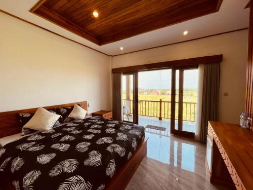 JembranaSurfers Villa and Resorts Medewi的一间带大床的卧室和一个阳台