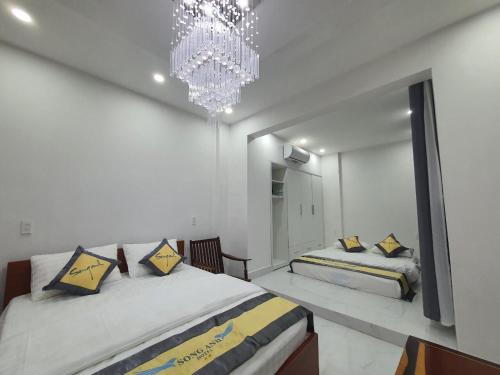邦美蜀Song Anh Hotel的一间卧室配有两张床和吊灯。