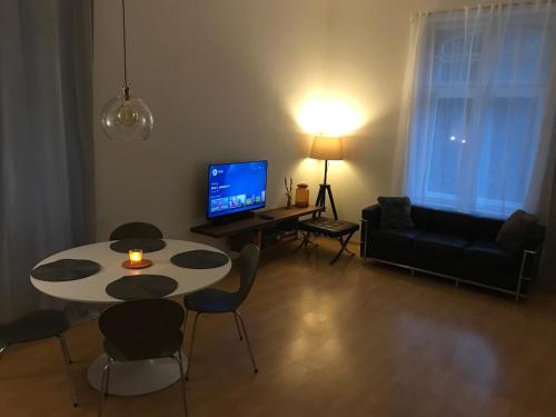 塞默灵Apartment 26 Eighty的客厅配有桌椅和电视。