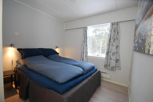 FlesbergFossanåsen Hotel的一间卧室设有一张大蓝色的床和窗户