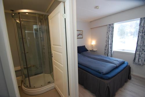 FlesbergFossanåsen Hotel的一间卧室设有淋浴和一张蓝色床单。