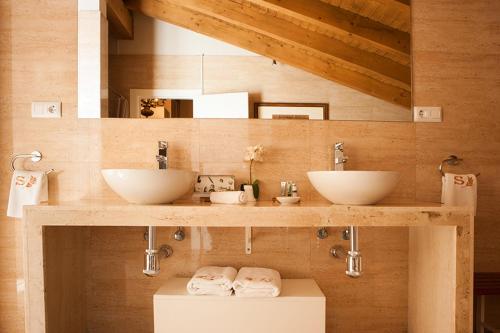 MorteraSotobosque的木墙上带两个水槽的浴室