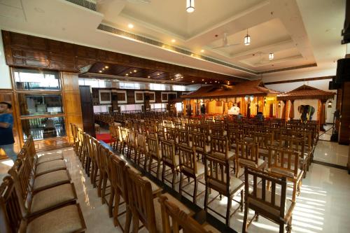 古鲁瓦尤尔Hotel Guruvayur Darshan的建筑里一排椅子的房间