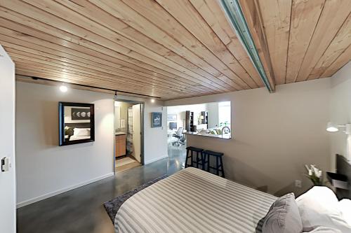 西雅图19th Avenue Lofts Unit 213的一间卧室设有一张床和木制天花板