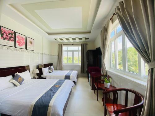 昆岛Khách Sạn Minh Thắng的酒店客房设有两张床和窗户。