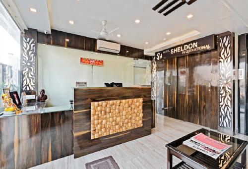 加尔各答Hotel Sheldon International Near Science City的餐厅设有木镶板柜台