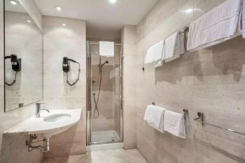 菲乌米奇诺Rome Airport Hotel Fiumicino的一间带水槽和淋浴的浴室