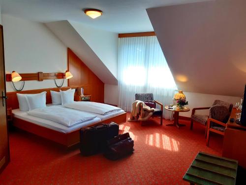 巴登-巴登埃尔哈妮酒店的酒店客房带一张床、一张桌子和椅子